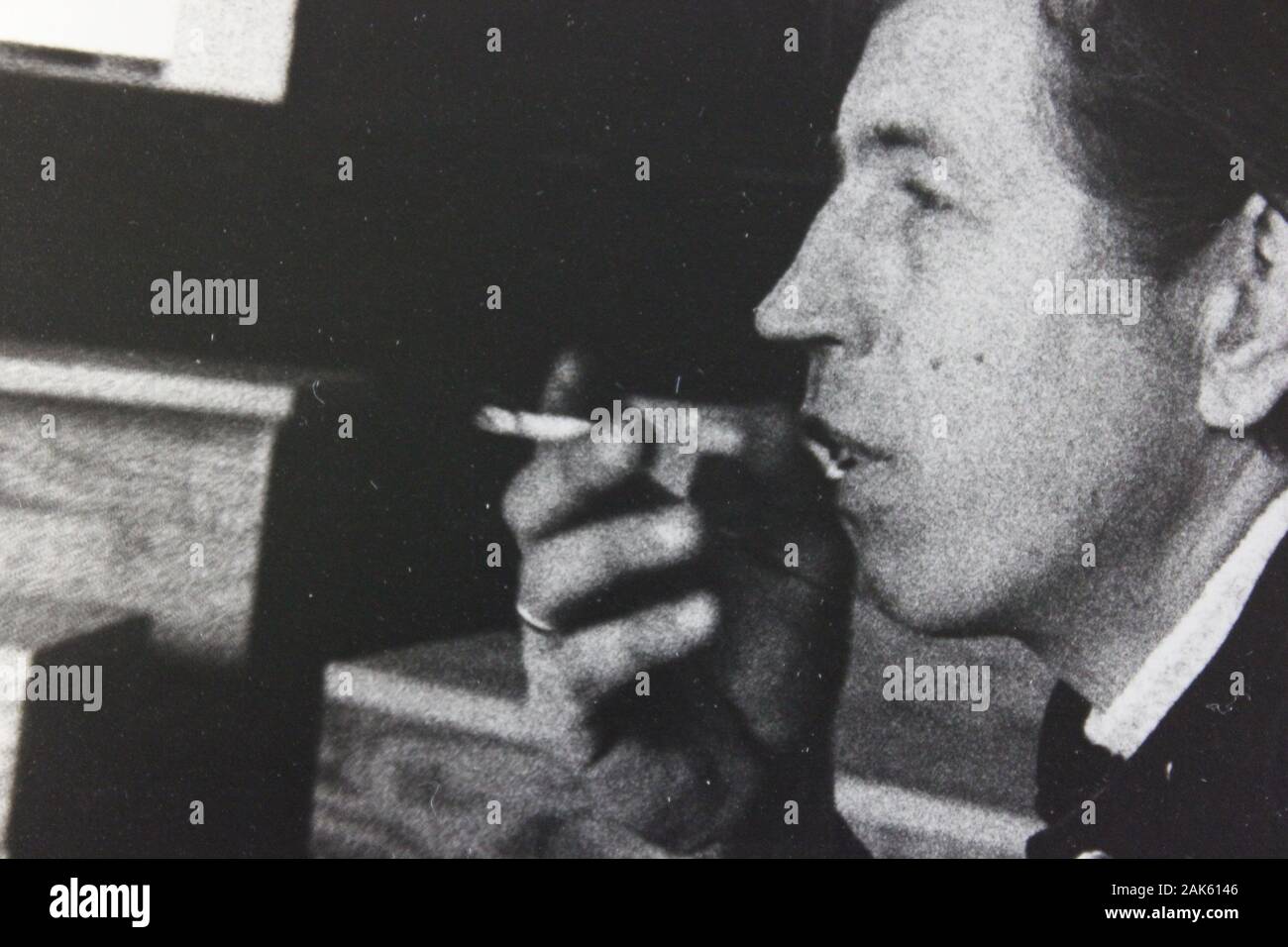 Belle photographie d'époque noir et blanc des années 1970 d'un homme qui fume une cigarette Banque D'Images