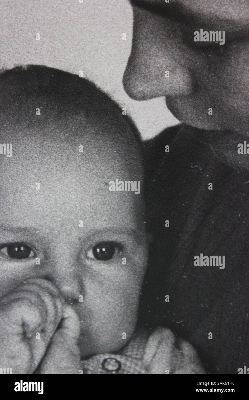 Belle Photographie Vintage Noir Et Blanc Des Annees 70 D Un Bebe Attentif Assis Dans Les Bras De Sa Mere Photo Stock Alamy