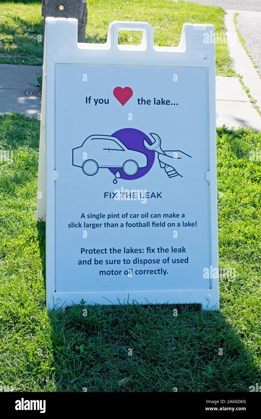 Un signe d'avertissement de fixer une fuite d'huile voiture car qui affecte les lacs afin effectuer les réparations. Minneapolis Minnesota MN USA Banque D'Images