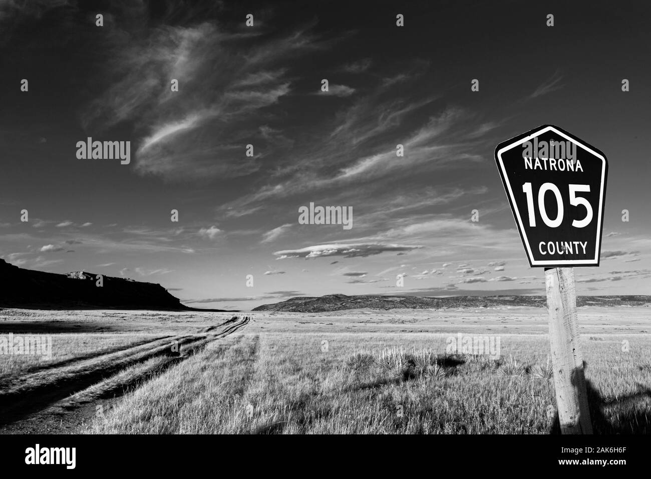 WY04129-00-BW...WYOMING Natrona County Road 105 - est une route de terre défoncée que cust à travers les terres d'herbe. Banque D'Images