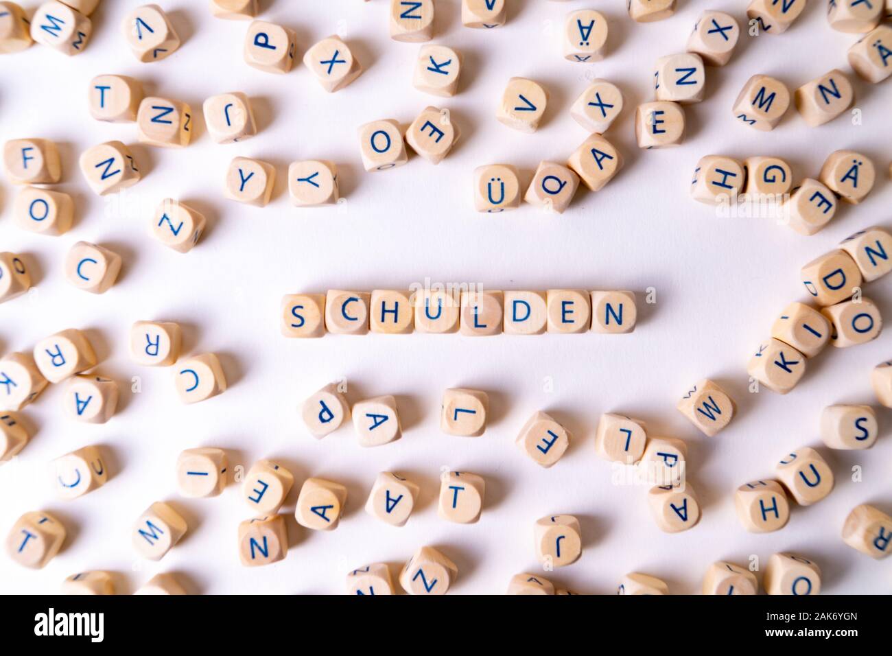 Cubes de lettres le mot 'Schulden bâtiment', l'allemand pour la dette, perdre les cubes au hasard autour de la pose Banque D'Images