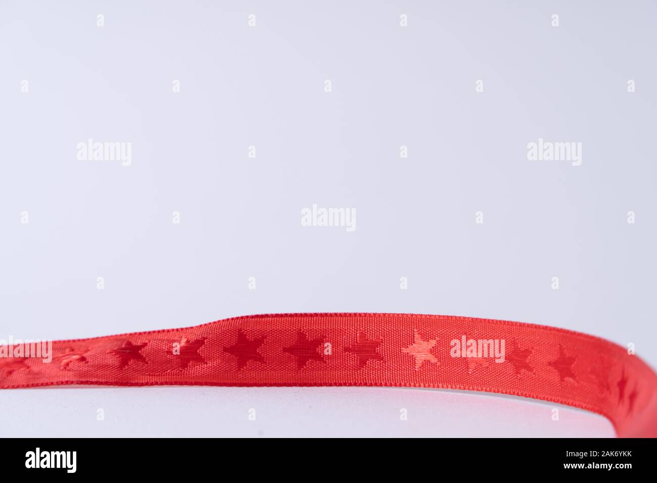 Un ruban rouge avec des étoiles, une trame sur fond blanc Banque D'Images