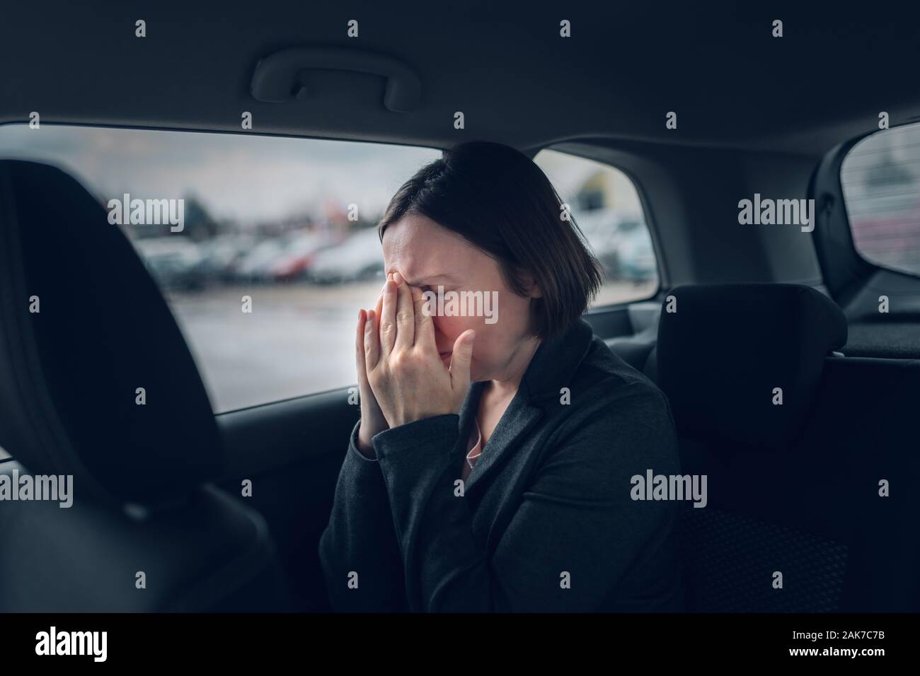 Businesswoman having migraine en voiture de société pendant la conduite au travail, selective focus Banque D'Images
