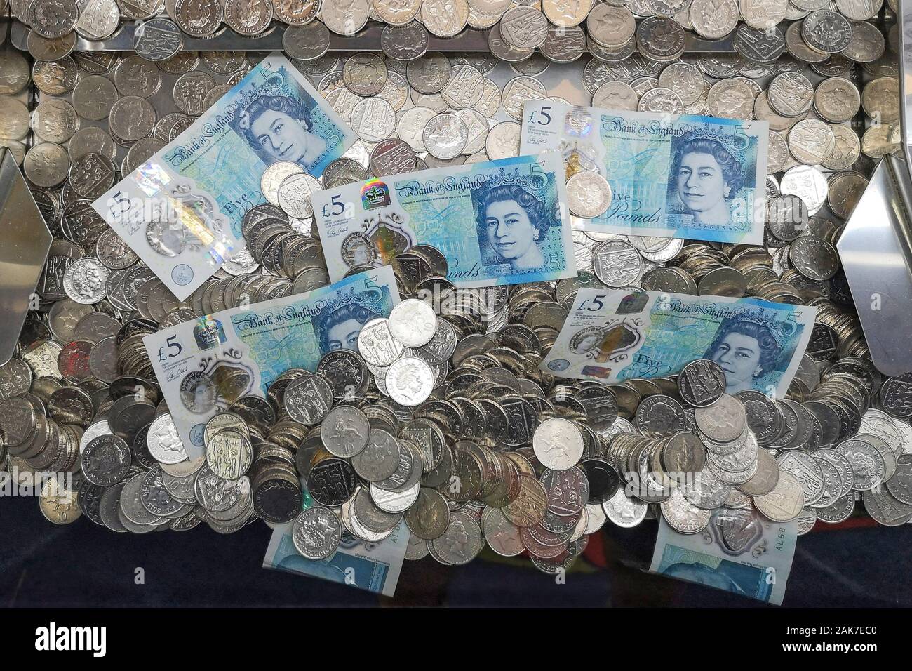 L'argent est vu dans un 'coin pusher'' arcade à Swanage, Dorset, novembre 2019. Banque D'Images