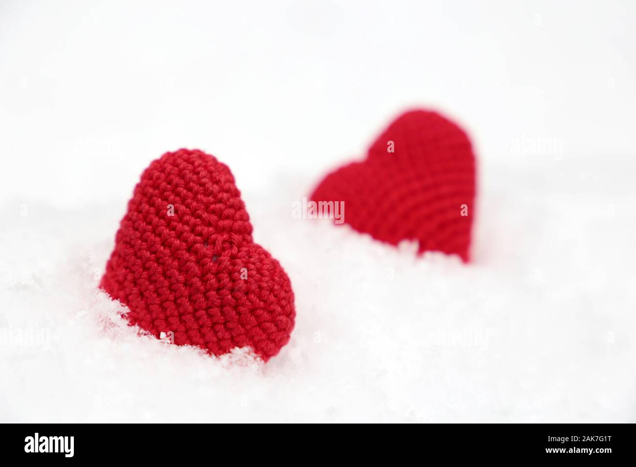 Coeurs d'amour, Carte de Saint-Valentin, deux symboles de passion tricot rouge dans la neige. Arrière-plan de l'événement célébration ou romantique, temps d'hiver Banque D'Images