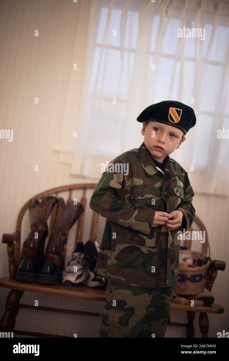 Un petit garçon porte son uniforme militaire. Banque D'Images