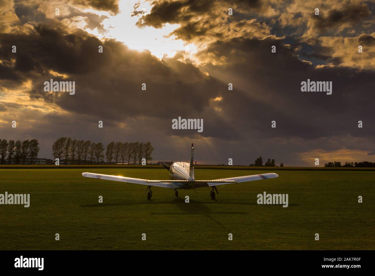 Piper P28 Cherokee avion sur un terrain d'aviation vide au coucher du soleil Banque D'Images