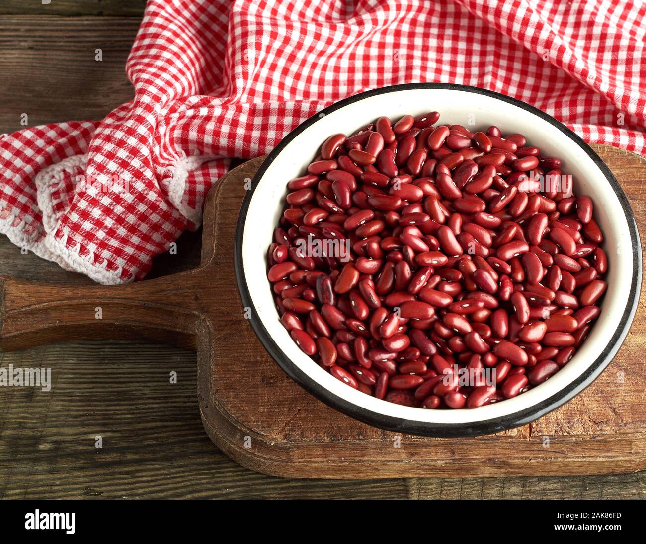 Ovale brut haricots rouges dans une assiette sur une table en bois. Repas biologiques. Aliments naturels sains végétariens. Banque D'Images