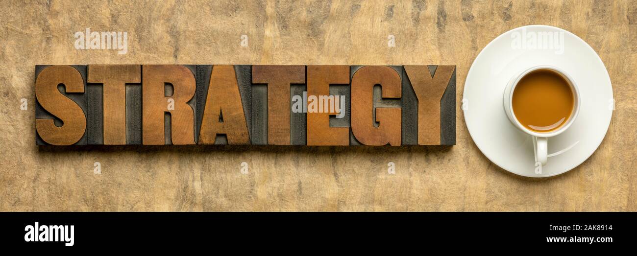 Mot stratégie dans la typographie vintage bois type contre le papier fait main texturée avec une tasse de café, la planification d'entreprise concept Banque D'Images