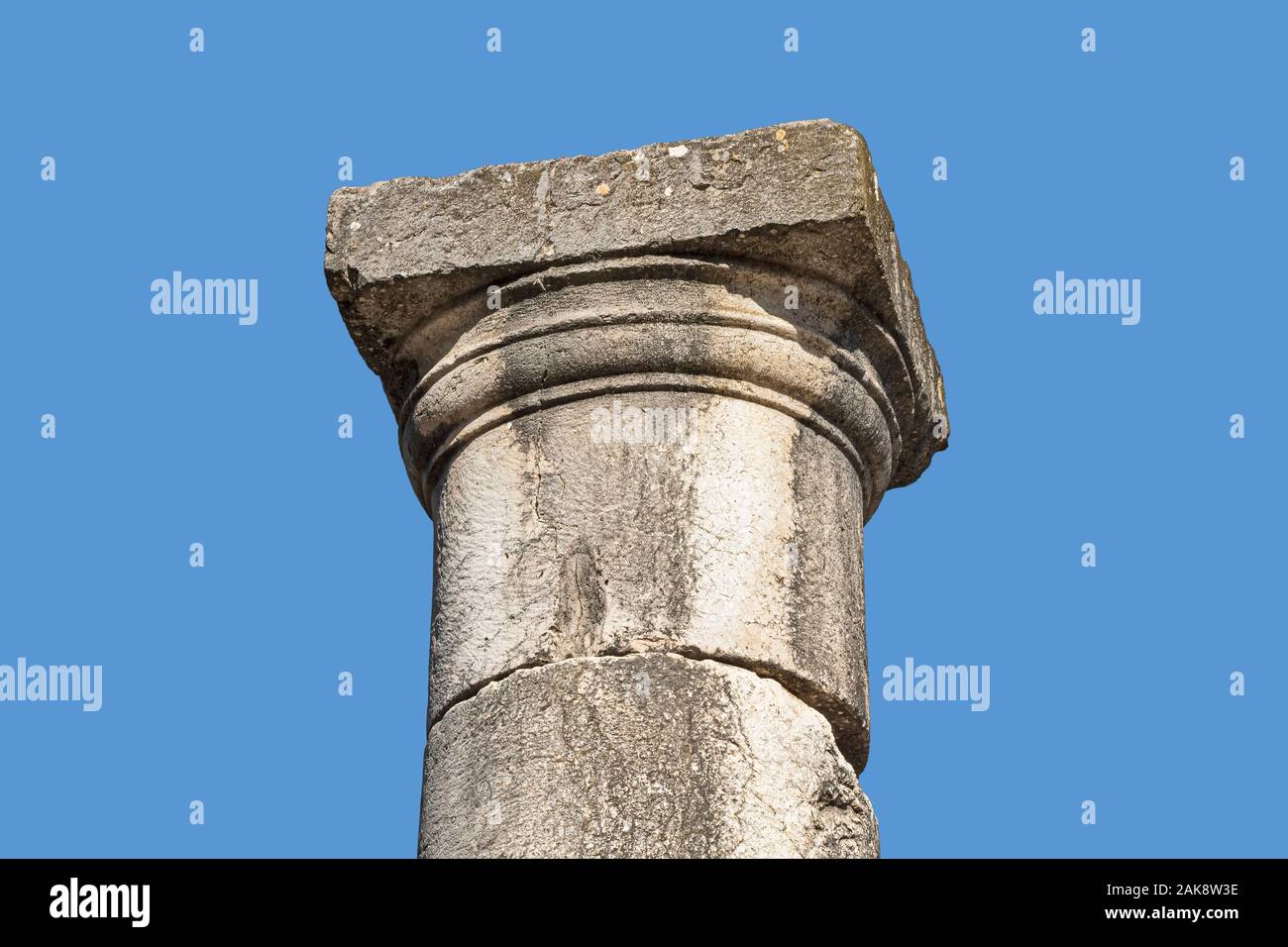 En pierre de basalte capital dans le style dorique grec au sommet d'une colonne simple avec un fond bleu ciel à Bar'am Park en Israël Banque D'Images