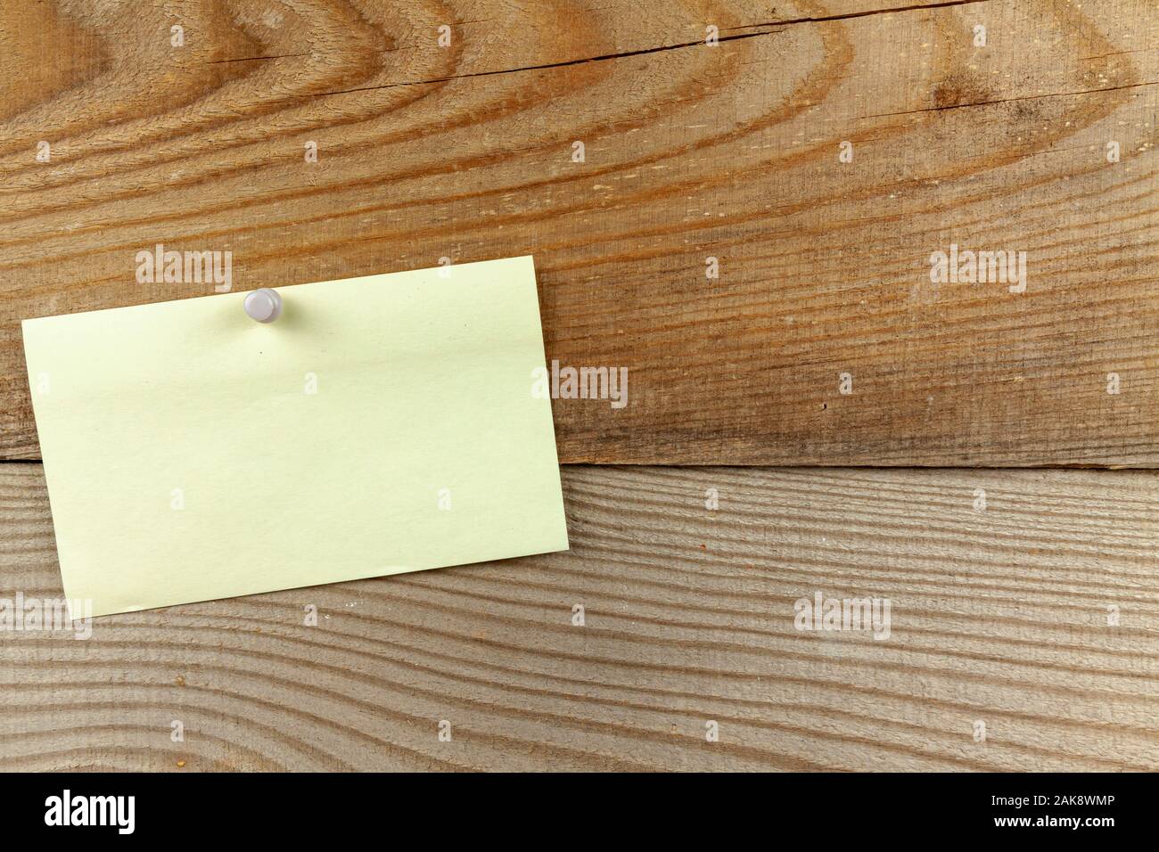 Épinglé un morceau de papier se bloque sur un mur en bois. Banque D'Images