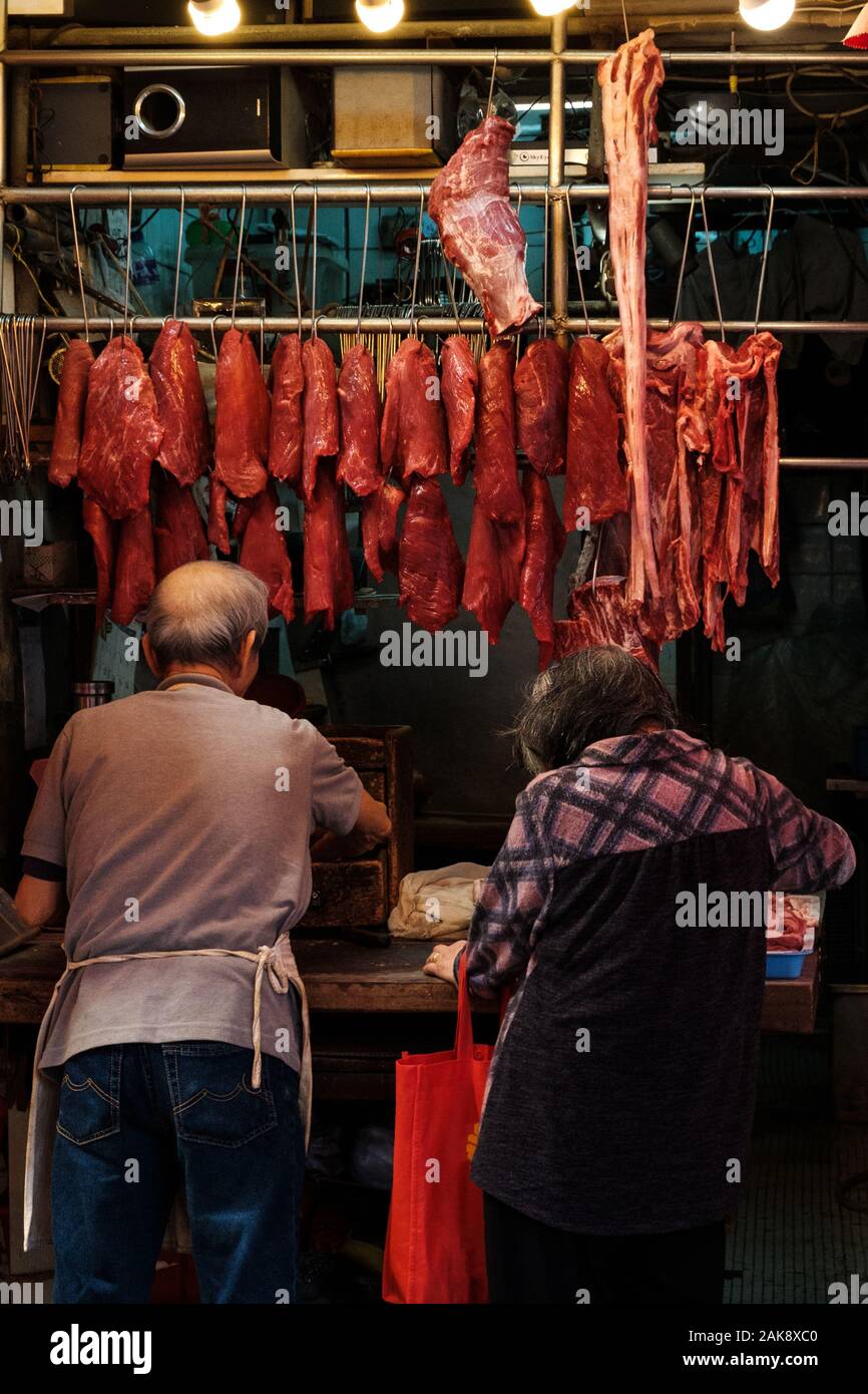 Hong Kong, Chine - Novembre 2019 : boucher vendant de la viande de femme plus âgée sur street market store à Hong Kong Banque D'Images