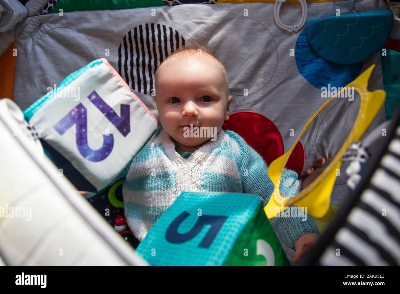 Un Bebe Regardant La Camera Joue Sur Un Tapis De L Activite Developpement Sensoriel Photo Stock Alamy