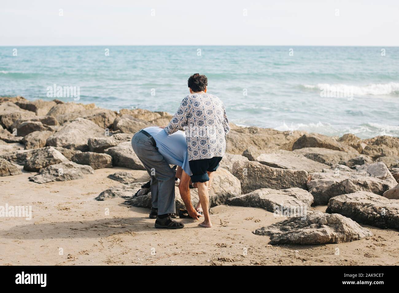 Un homme âgé d'aider sa femme en marchant sur la plage. Vilanova i la Geltrú, Barcelone. Espagne Banque D'Images
