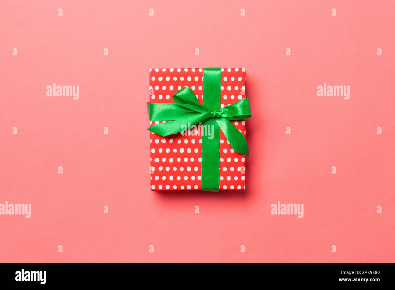 Vue d'en haut cadeau de Noël fort avec bow vert sur fond corail vivant avec  l'exemplaire de l'espace Photo Stock - Alamy