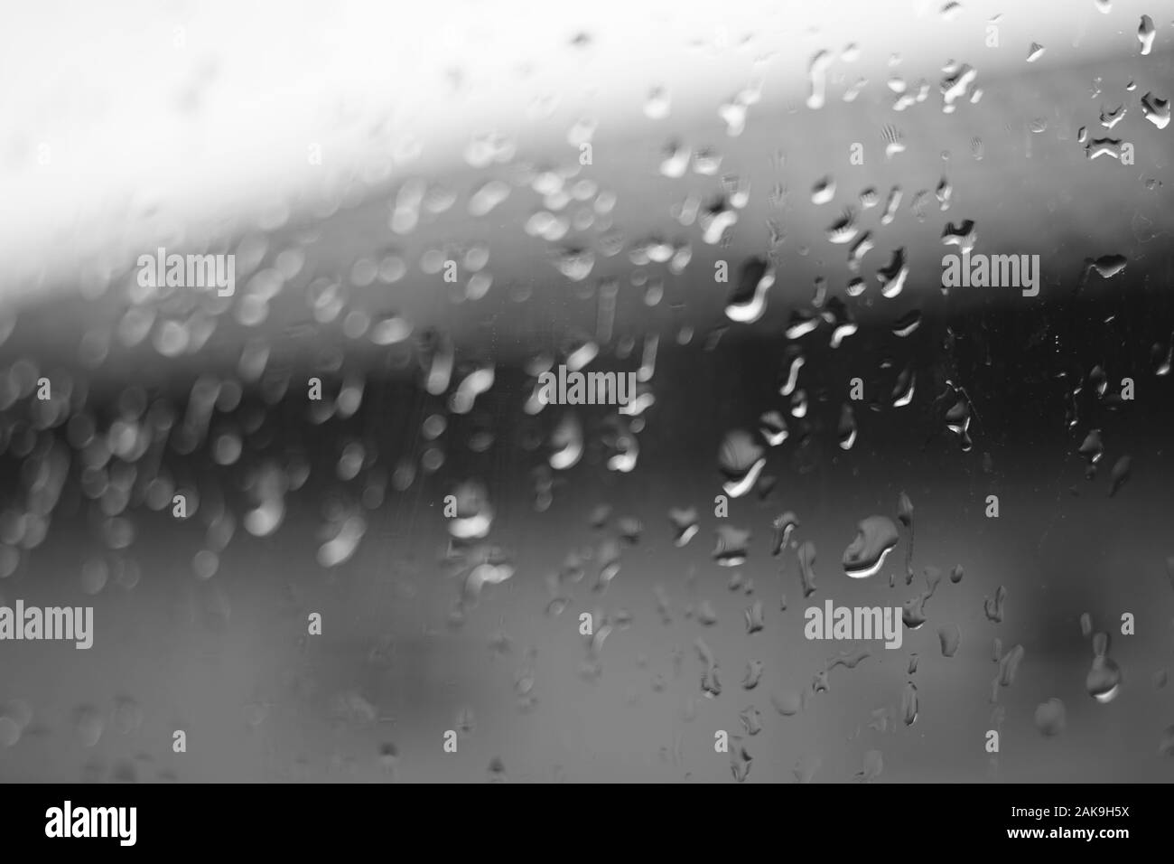 Fenêtre humide avec des gouttes de pluie, bw macro image. Banque D'Images