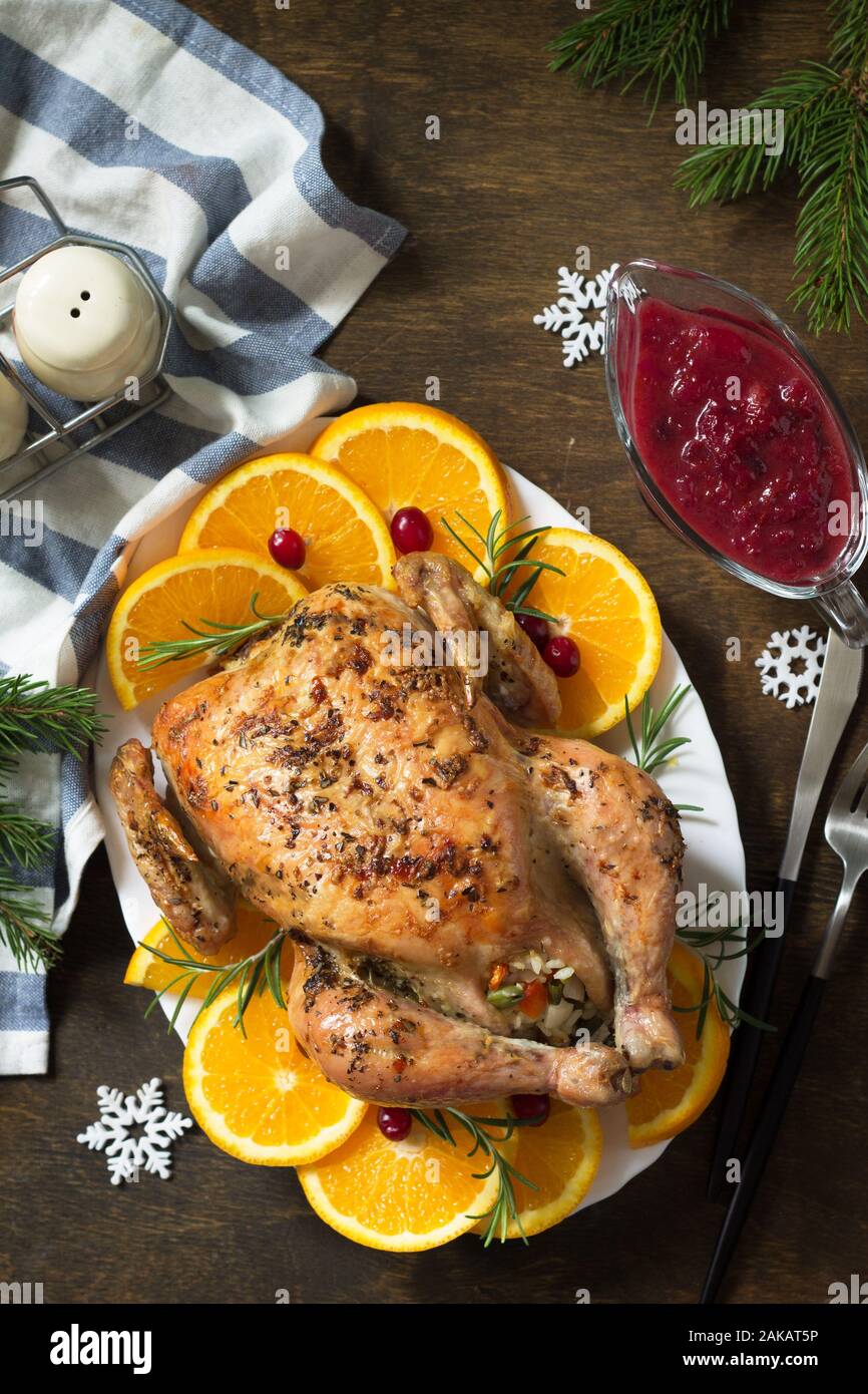 Concept de Noël ou Nouvel An dîner rôti de dinde farci de riz et de la sauce aux canneberges sur table en bois. Vue d'en haut. Banque D'Images