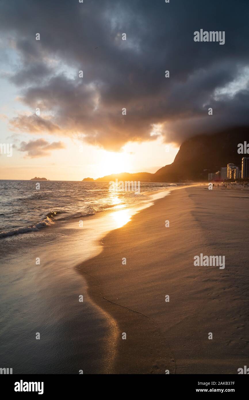 Un coucher de soleil spectaculaire avec des nuages autour de Pedra da Gávea sur Sao Conrado Beach, Rio de Janeiro, Brésil. Banque D'Images