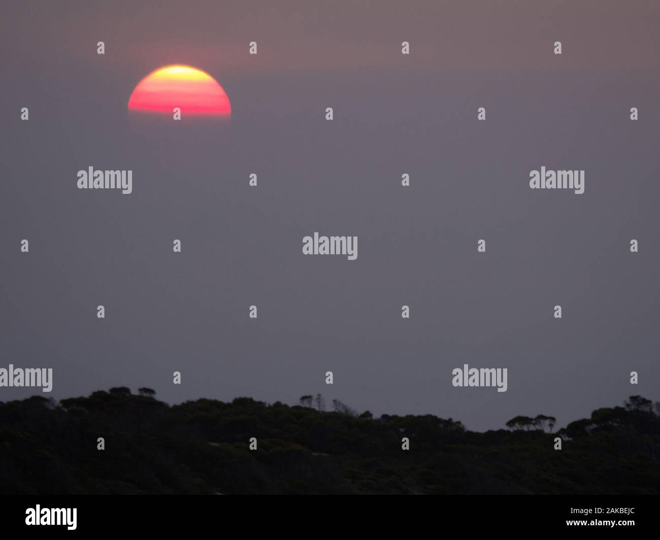 Coucher du soleil obscurci par la brume sèche du feu de brousse sur Kangaroo Island en Australie du Sud, Australie. Banque D'Images