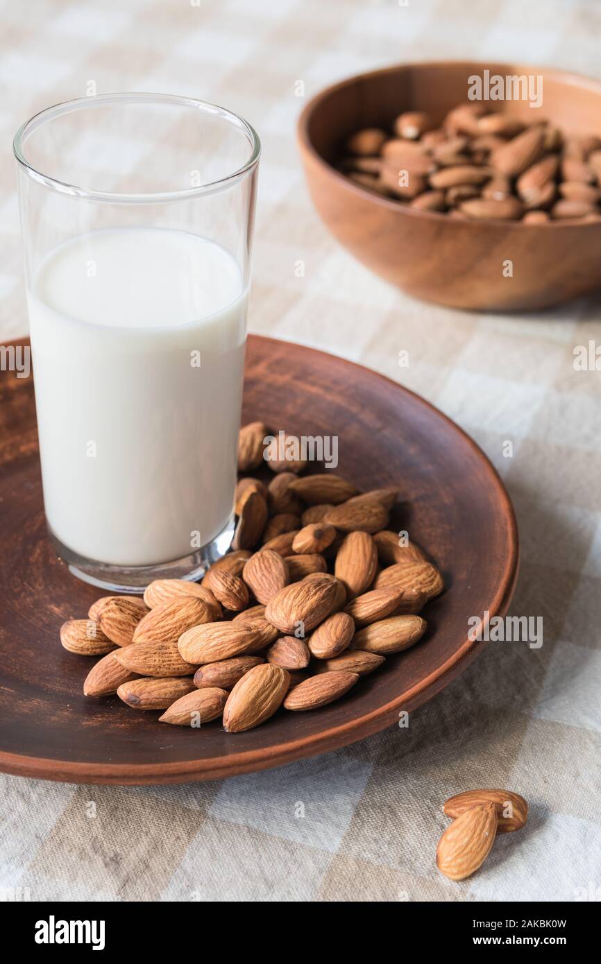 Concept d'aliments sains, les amandes et le verre de lait dans une assiette sur la table Banque D'Images