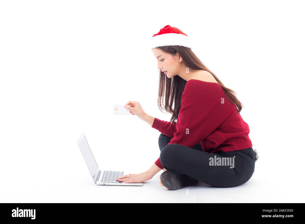 Jeune femme assise de l'achat sur internet pour paillasse et holding credit card vacances de Noël, 9 fois sur le portable en ligne fille dans la célébration de Noël, conc Banque D'Images