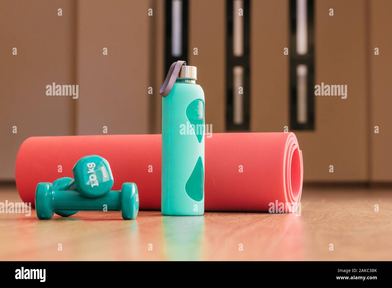 Stock photo de deux haltères, une bouteille et un tapis, objets de formation Banque D'Images