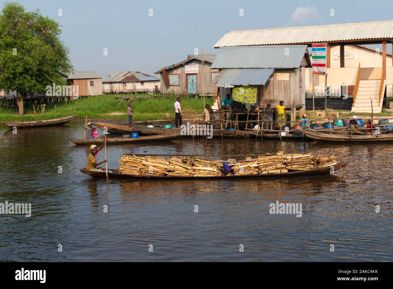 Le Bénin, ville au bord du lac de Ganvié, marchand de bois sur sa pirogue Banque D'Images