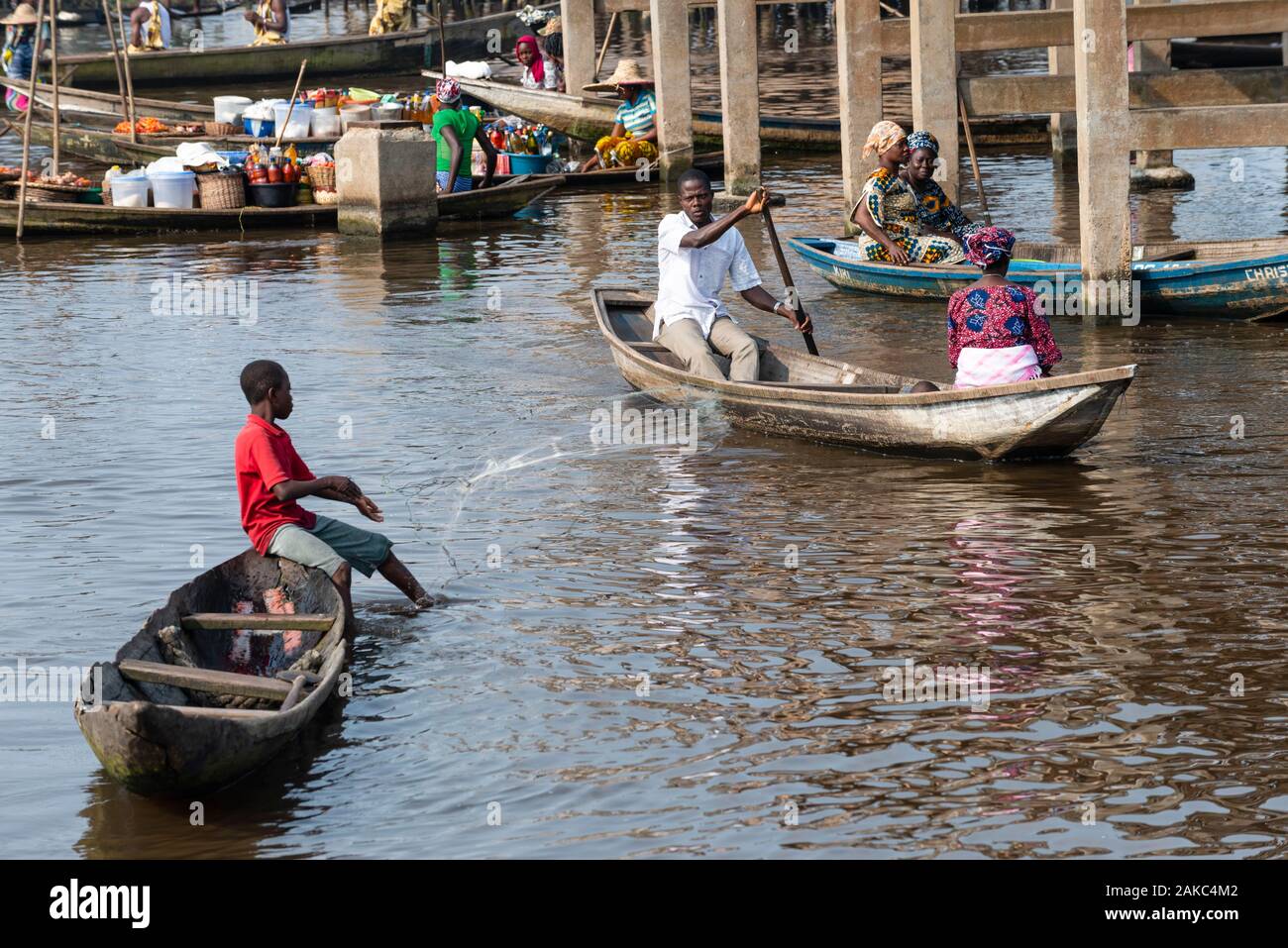 Le Bénin, ville au bord du lac de Ganvié, enfant, à lancer son filet de pêche en face de la place du marché flottant Banque D'Images