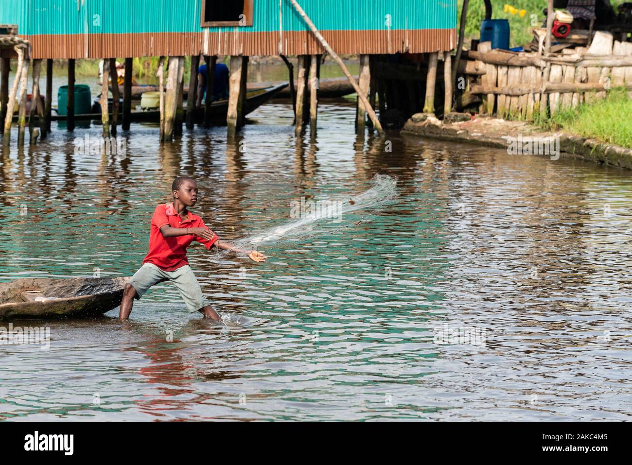 Le Bénin, ville au bord du lac de Ganvié, enfant, à lancer son filet de pêche Banque D'Images