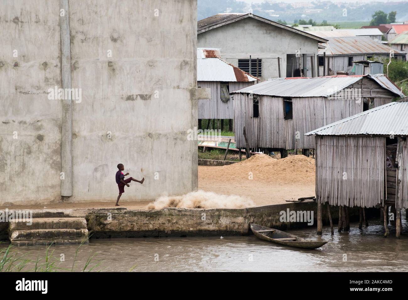 Le Bénin, ville au bord du lac de Ganvié, kid jouer en face de filets de pêche Banque D'Images