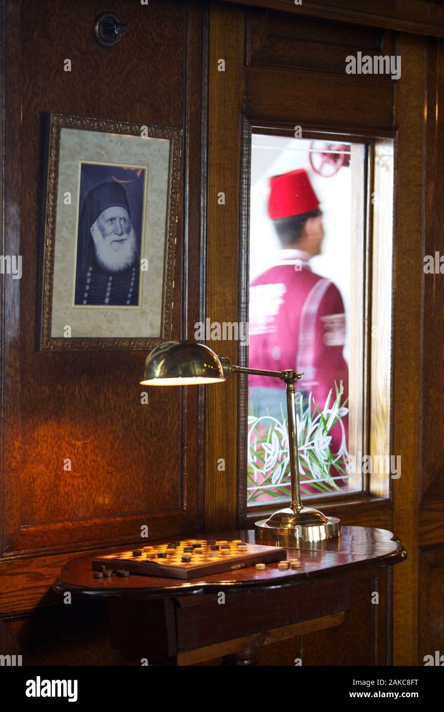 L'Égypte, de la Haute Égypte, vallée du Nil, Steam Ship Sudan lounge, le dernier bateau à vapeur sur le Nil, décorée d'une photo en noir et blanc d'un ancien pacha égyptien, avec un membre de l'équipage portant "un tarbouche en passant dans un couloir Banque D'Images