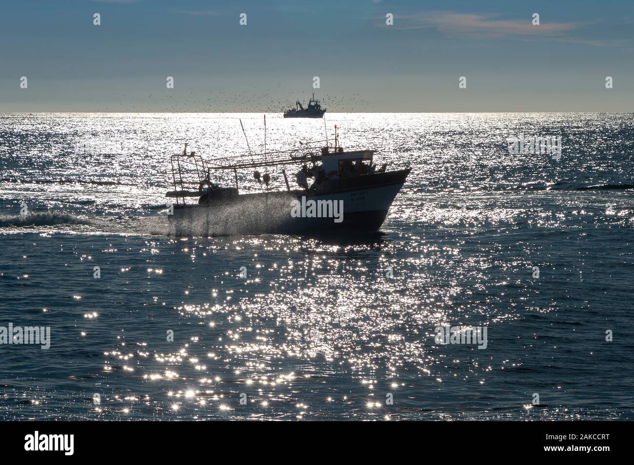 Les bateaux de pêche de retour à la maison avec une mer scintillante Banque D'Images