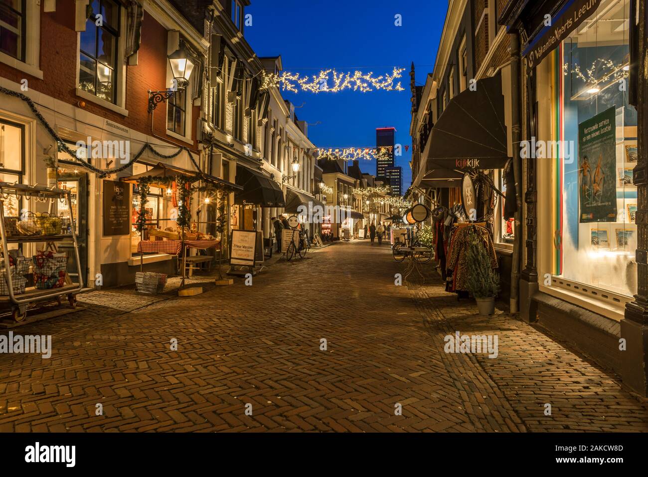 Les gens font des achats dans la 'Kleine Kerkstraat' au crépuscule. La rue est éclairée par des lumières de Noël. L 'Kleine Kerkstraat' à Leeuwarden est répéter Banque D'Images