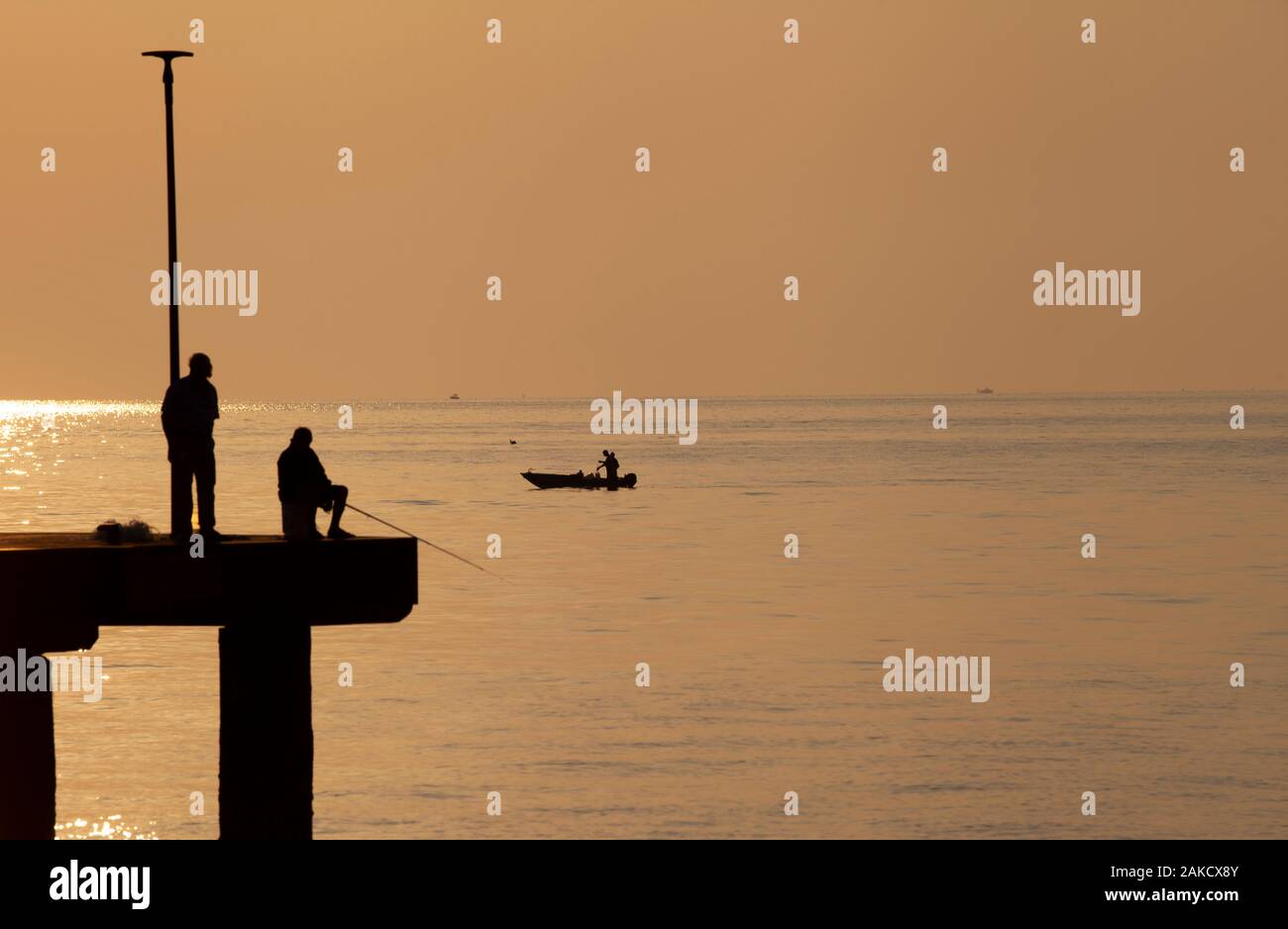 Silhouette jetée au petit matin avec des personnes actives (pier) vue partielle Banque D'Images