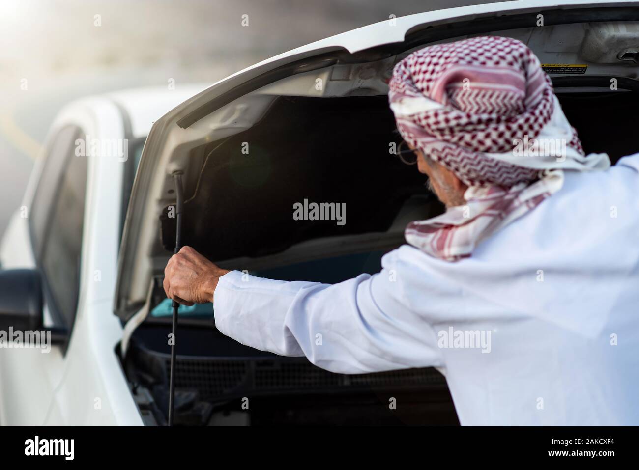Fixation de l'homme arabes Senior sa voiture à l'extérieur Banque D'Images