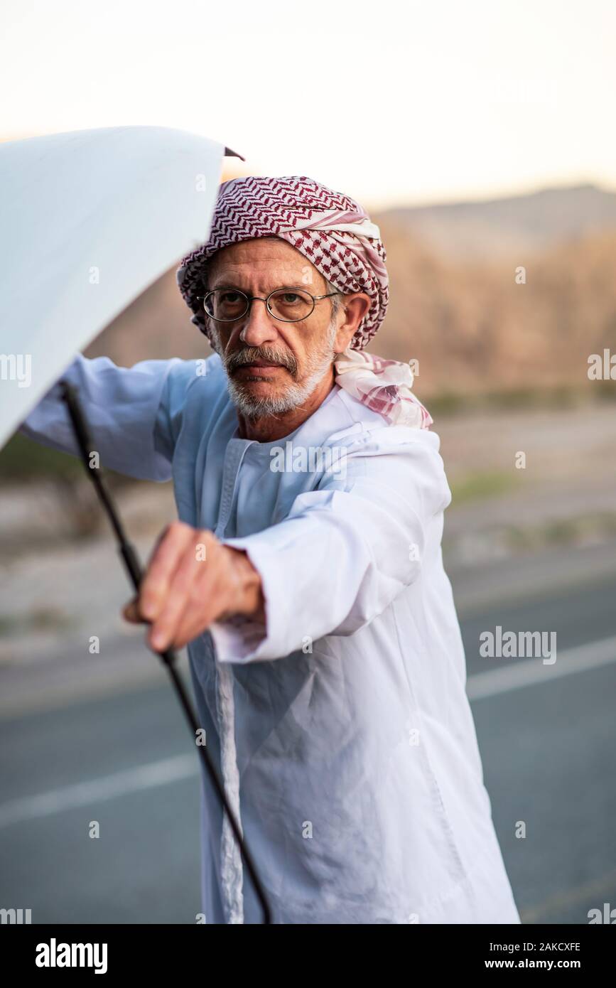 Fixation de l'homme arabes Senior sa voiture à l'extérieur Banque D'Images