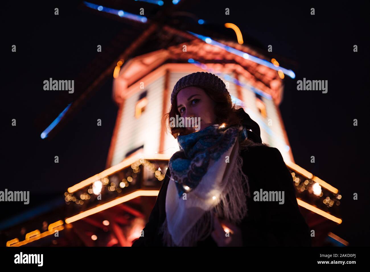 Portrait - jeune fille rousse attrayante de traîner dans le parc d'attractions avec des couleurs vives et des installations - fond attractions Banque D'Images
