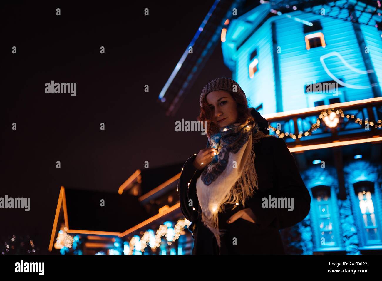 Portrait - jeune fille rousse attrayante de traîner dans le parc d'attractions avec des couleurs vives et des installations - fond attractions Banque D'Images