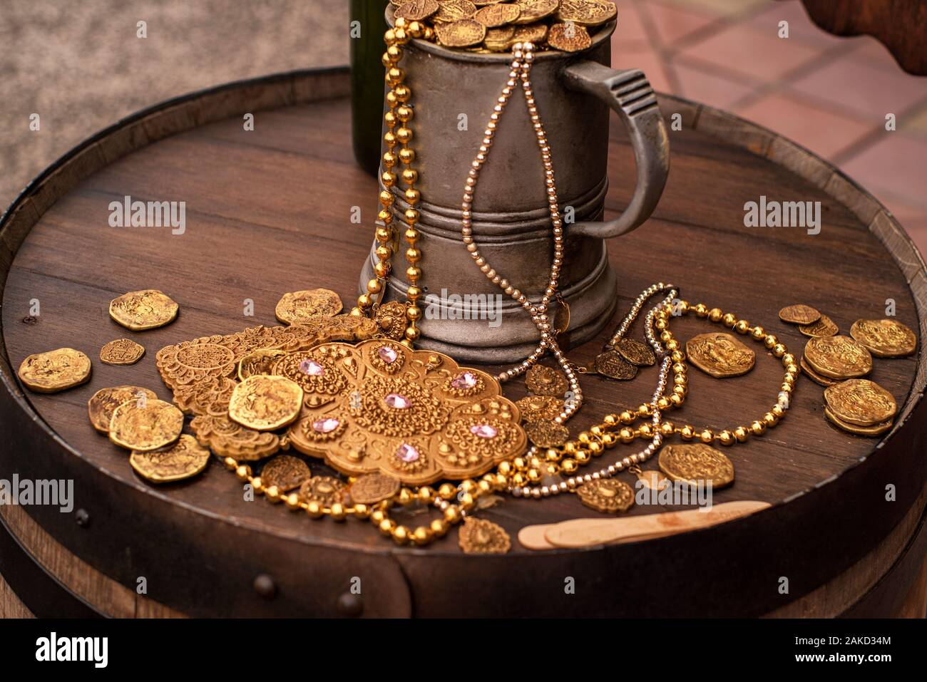 Jack Sparrow.Pièces Pièces d'or artificiel et une décoration sur un tonneau en bois. Un mug rempli avec de l'or monnaie artificielle. Banque D'Images