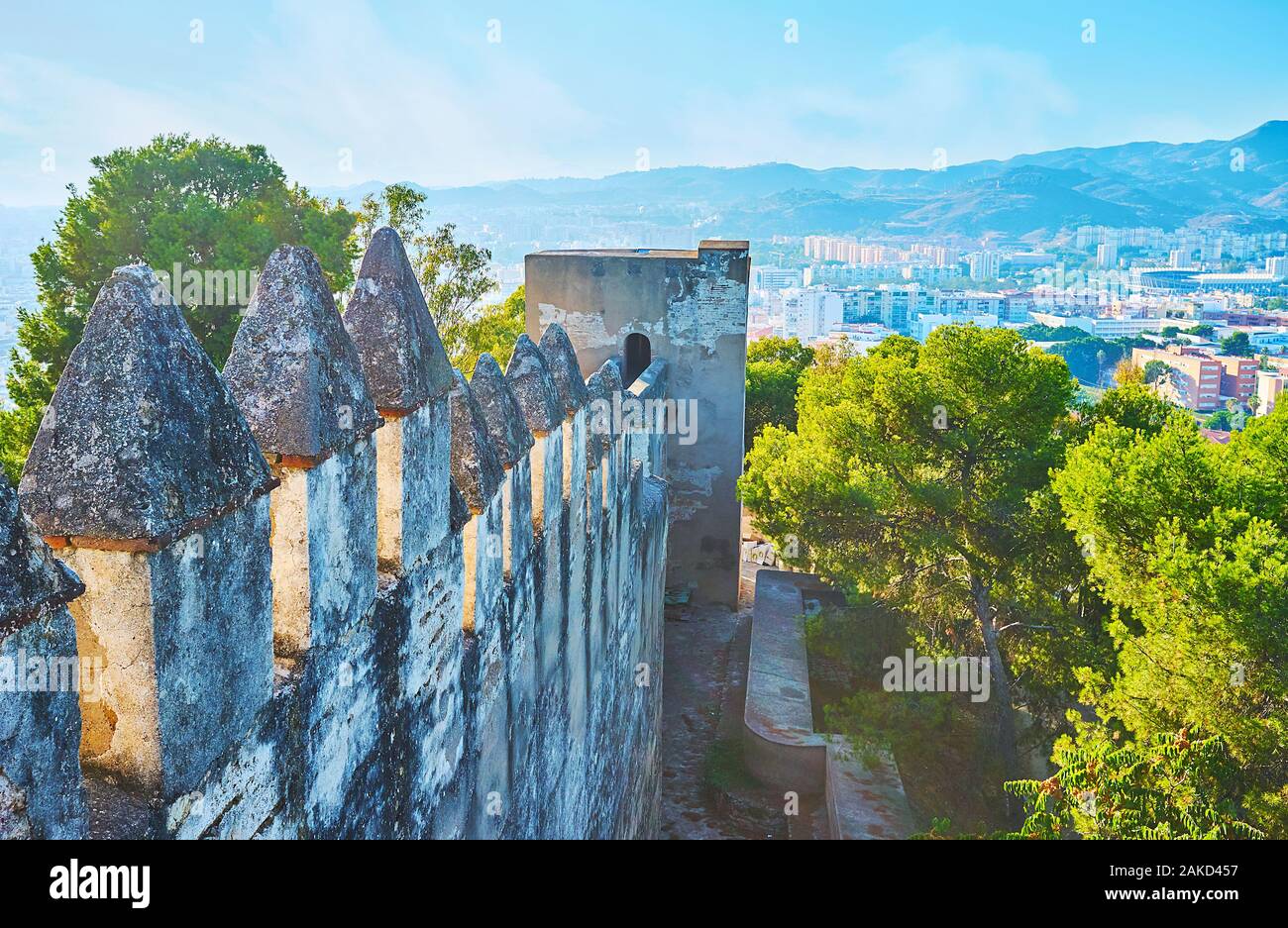 La vue sur le rempart médiéval à mâchicoulis et tour blanche de l'historique château de Gibralfaro Musulmane, situé sur la colline de la ville de Malaga, Espagne Banque D'Images