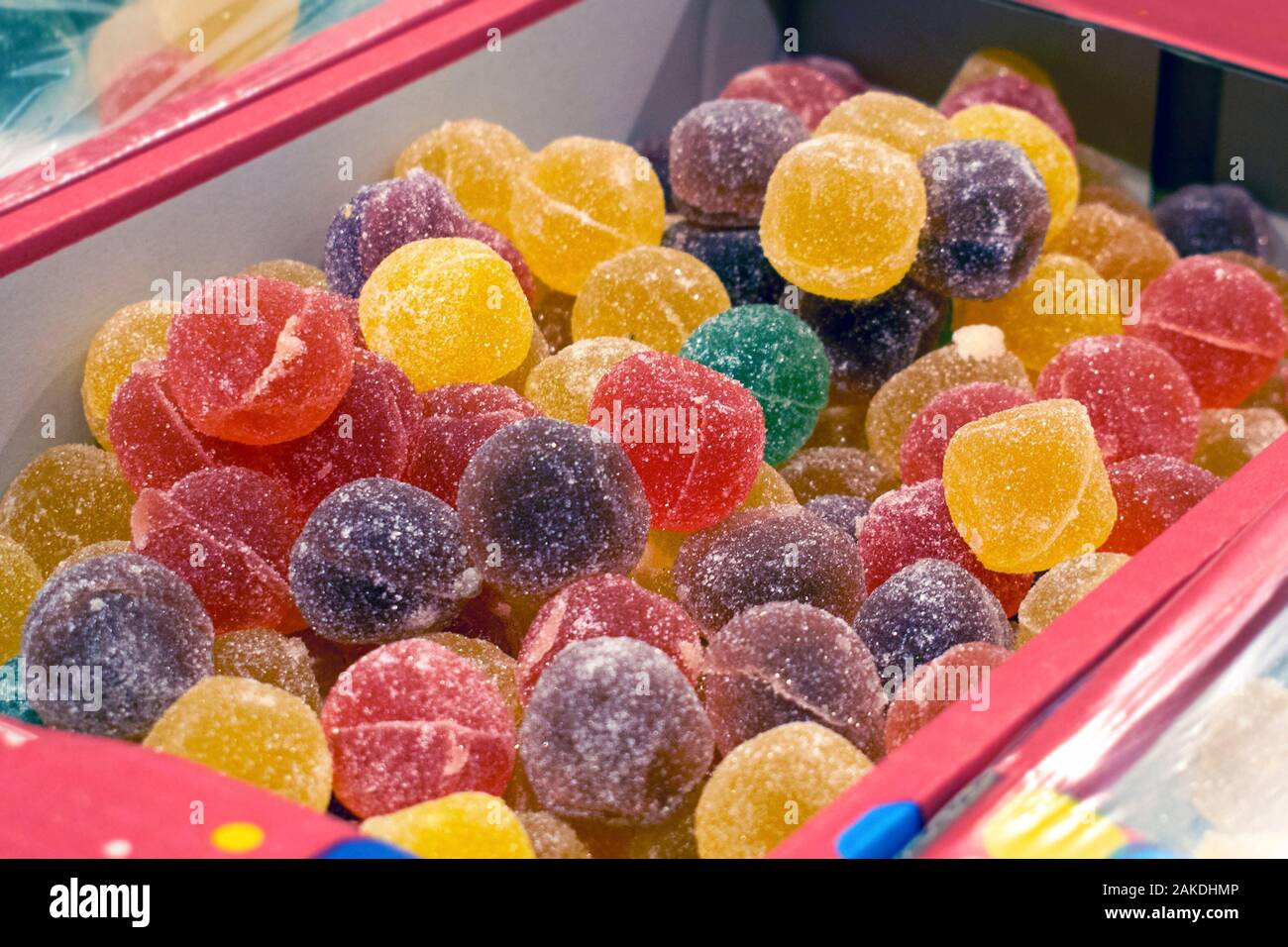 Bonbons de gelée de couleurs différentes dans une boîte, sur une étagère de supermarché. Boules rondes de marmelade dans le sucre. Banque D'Images