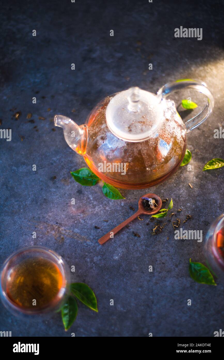 Théière en verre avec double paroi bols en verre sur une base en pierre  avec les feuilles de thé Photo Stock - Alamy
