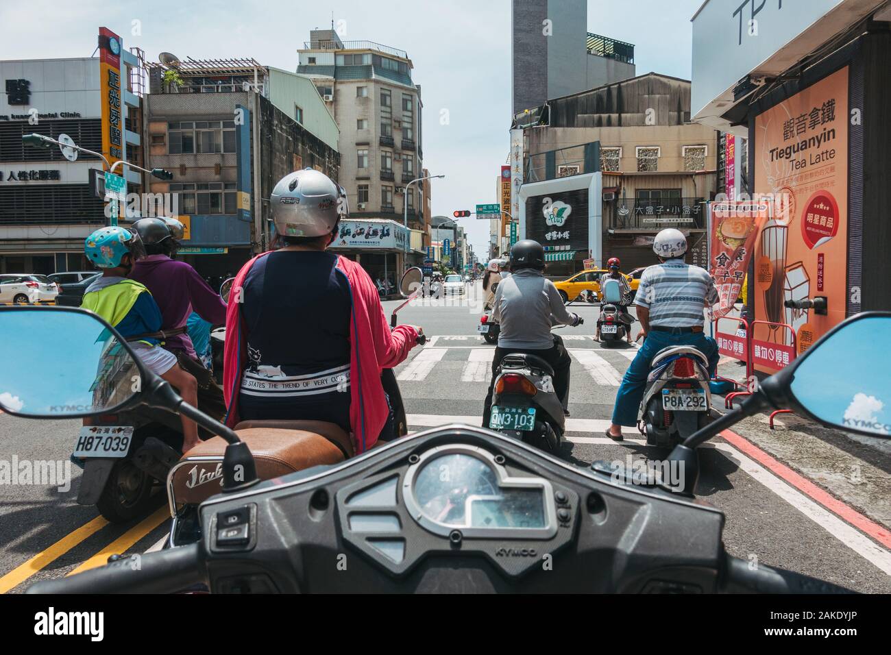 Les usagers de scooters attendre à une intersection sur une chaude journée à Tainan, Taiwan. Vu d'un autre point de vue du cavalier Banque D'Images