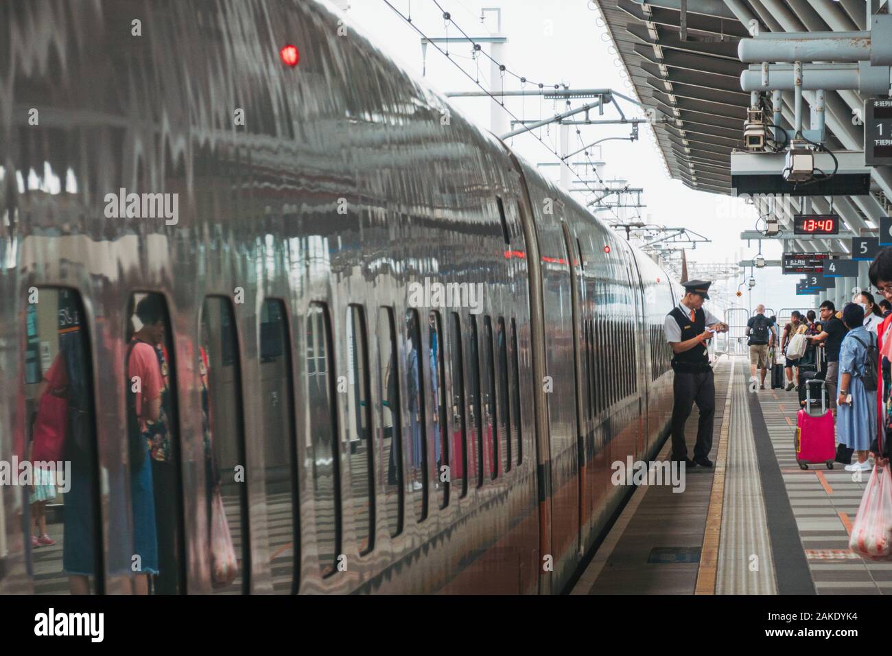 Un conducteur vérifie sa montre sur la plate-forme en tant que Taiwan High Speed Rail bullet train arrive à la gare TGV de Tainan, Taiwan Banque D'Images