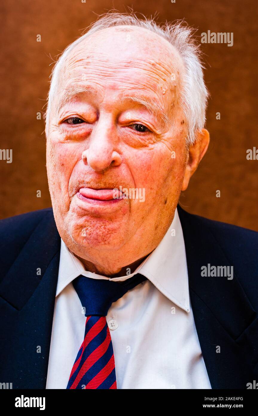 Portrait de vieil homme blanc positif avec costume sombre, chemise blanche  et cravate rouge bleu rayé montrant sa langue avec l'oeil sur fond marron  clair Photo Stock - Alamy
