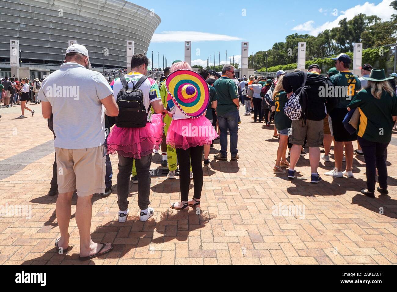 Des gens habillés en fancy dress costumes faire la file d'attente et d'entrer dans le Cape Town Stadium pour le tournoi de rugby à 7 en Afrique du Sud Banque D'Images