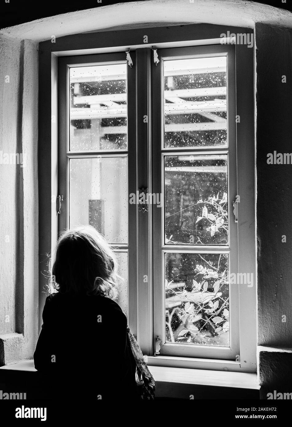 Vieille Femme à la fenêtre des pluies. Banque D'Images