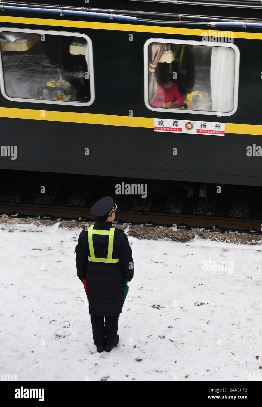 (200109) -- BAOJI, le 9 janvier 2020 (Xinhua) -- Sous-officier Zhao Shuai se félicite du train à la gare la plus Qingshiya sur le sommet de montagnes Qinling dans Baoji Ville, nord-ouest de la Chine, Province du Shaanxi, le 7 janvier 2020. La gare la plus Qingshiya est au sommet de montagnes Qinling sur le premier chemin de fer électrifié, Baoji - Chengdu railway. Entouré de falaises, le 'cloud station' se compose de seulement deux pistes et sert comme un court arrêt pour le passage des trains sur la voie ferrée. Petit comme il est, la station dispose de tous les organes vitaux. Pour garantir le fonctionnement de la gare, statio Banque D'Images