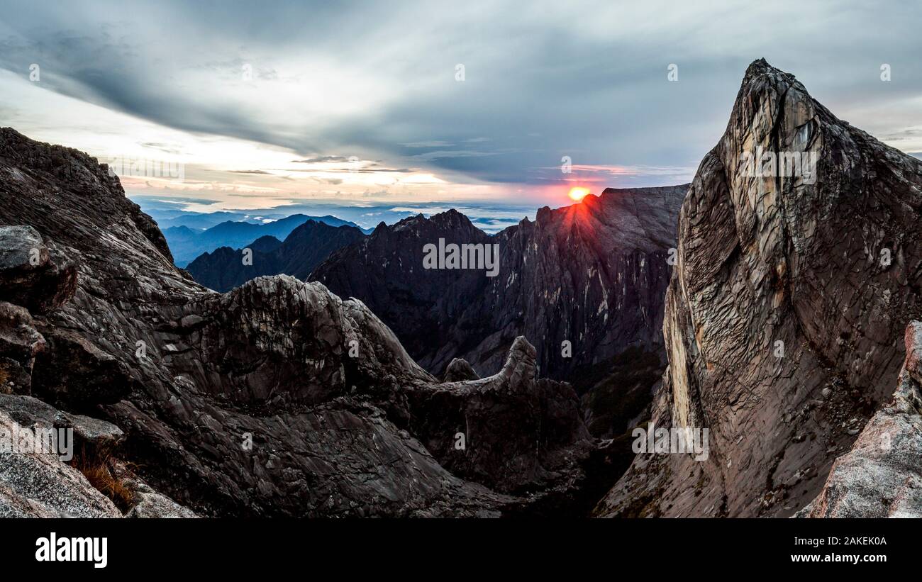 Lever du soleil comme vu plus bas's Gully et sœur laide, pointe de la base du pic du bas (environ 4000 mètres), le Mont Kinabalu. Bornéo, mai 2013. Banque D'Images
