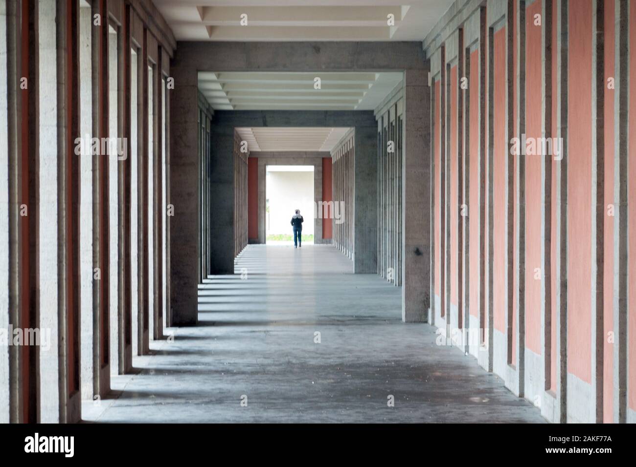 Weimar, Allemagne. 15 Nov, 2019. Une jeune femme se promène dans un portique à l'arrière de l'Administration de l'état de Thuringe. Ce bâtiment classé complexe fait partie de l'ancien Gauforum et a été entièrement rénové depuis 2012. Credit : Soeren Stache/dpa-Zentralbild/ZB/dpa/Alamy Live News Banque D'Images